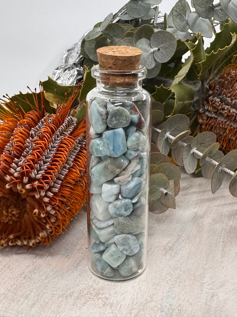Glass bottle filled with Larimar crystal chips in soothing ocean-blue tones — stone of serenity, communication, and divine feminine energy.