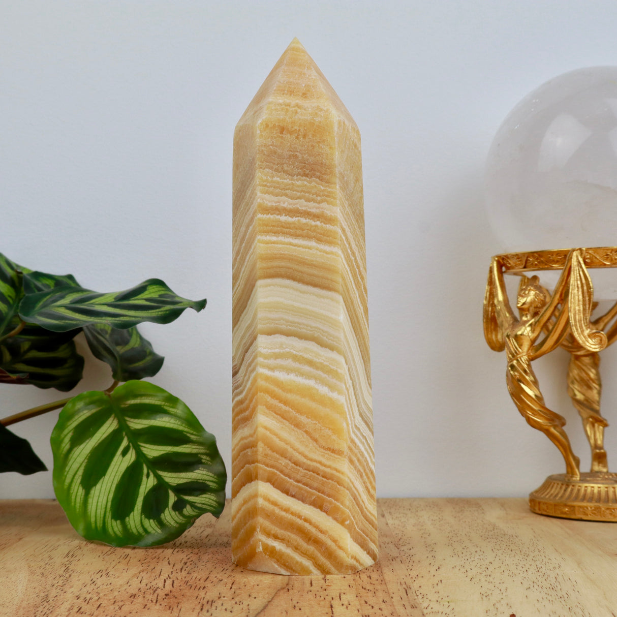 18cm Orange Calcite tower weighing 629g with honey and cream banding polished into a point.