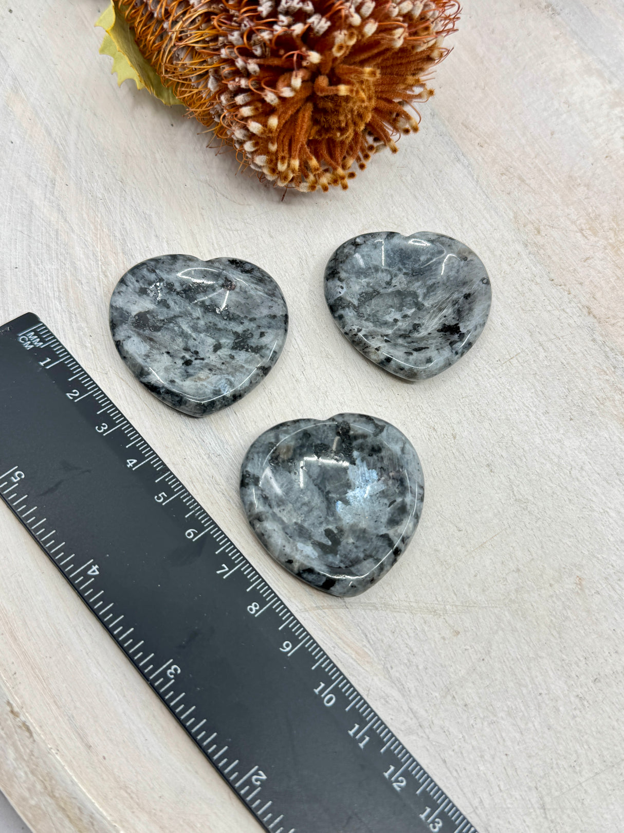 Larvikite heart worry stone next to a ruler 4x4cm with thumb indent – one piece – dark crystal with blue flashes for protection, grounding and intuition – Inspired By 3 Crystals Australia.