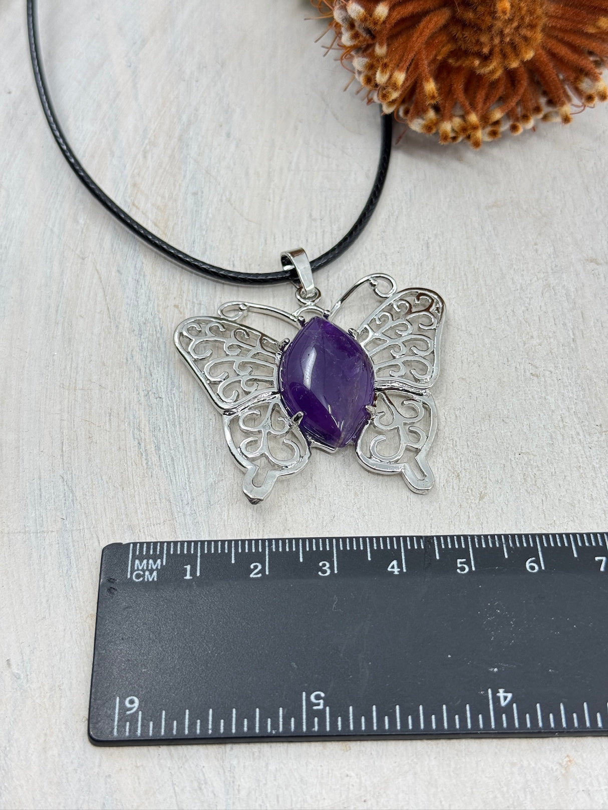 Amethyst butterfly pendant platinum tone brass 43x45x7mm – healing crystal for calm, transformation and spiritual growth – shown with ruler