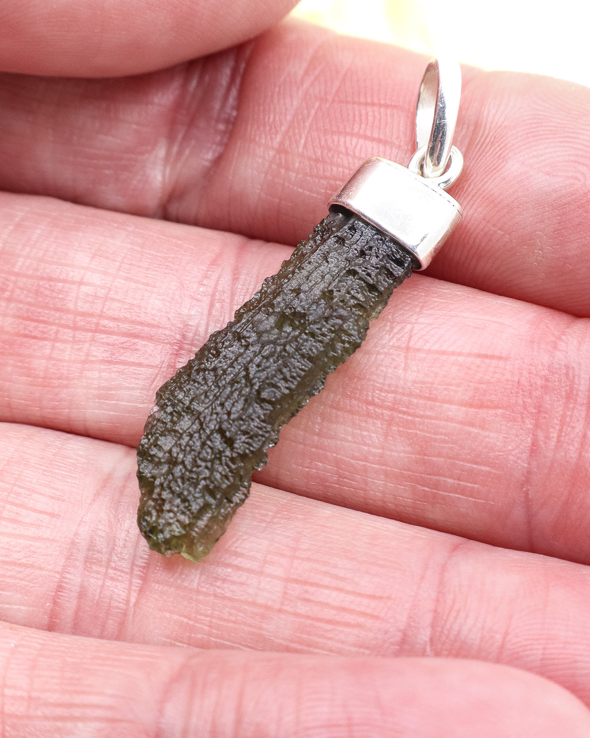 Genuine Czech Moldavite pendant set in .925 sterling silver featuring a natural elongated green Moldavite specimen from the Czech Republic.