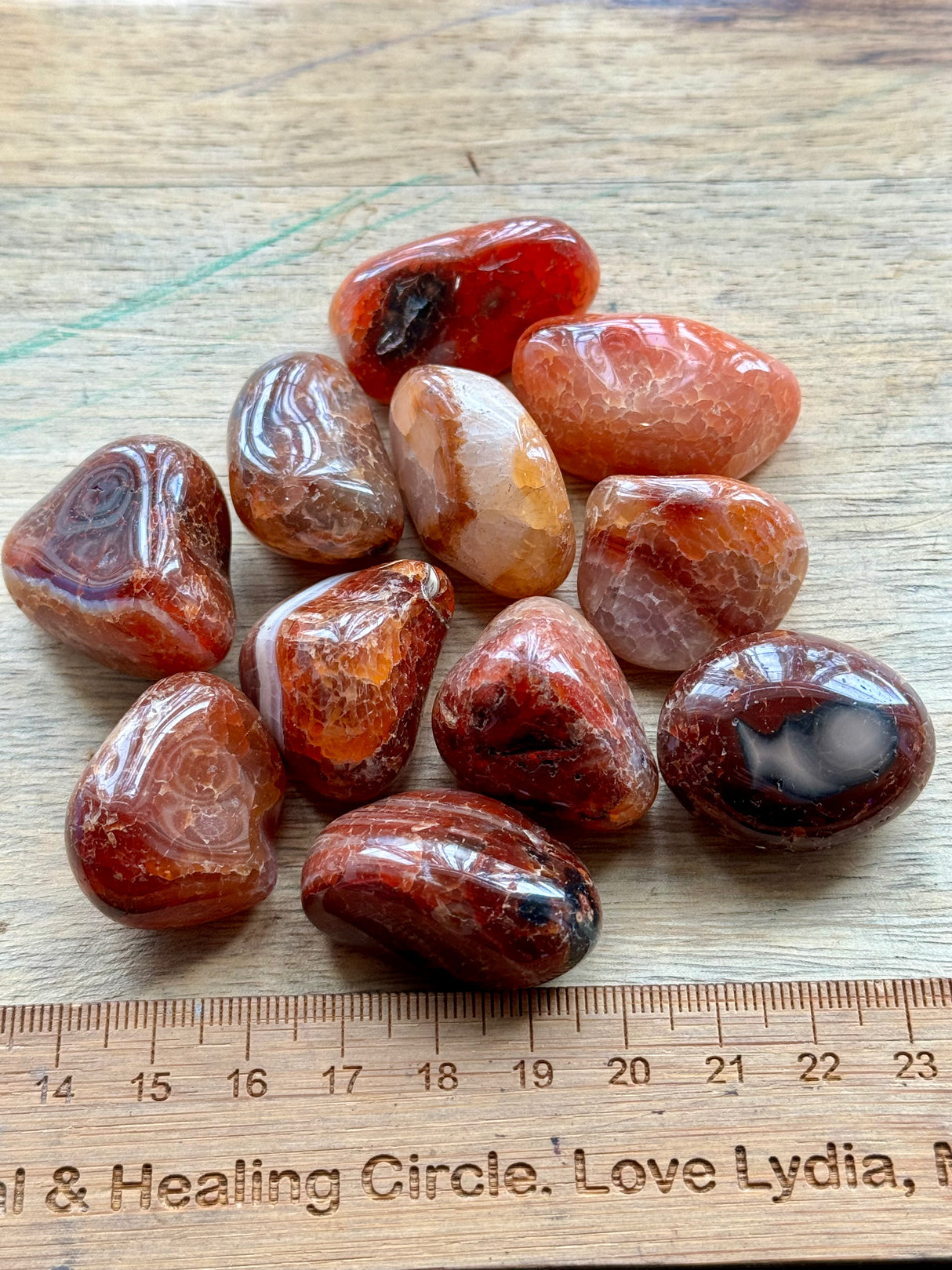 Fire Agate tumbled stone with fiery red and brown flashes — crystal of vitality, courage, and divine protection.