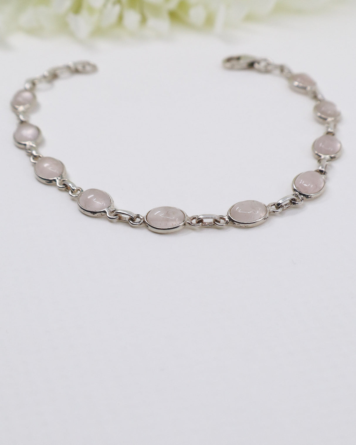 Delicate sterling silver Rose Quartz bracelet with soft pink gemstones displayed beside ruler for size reference.