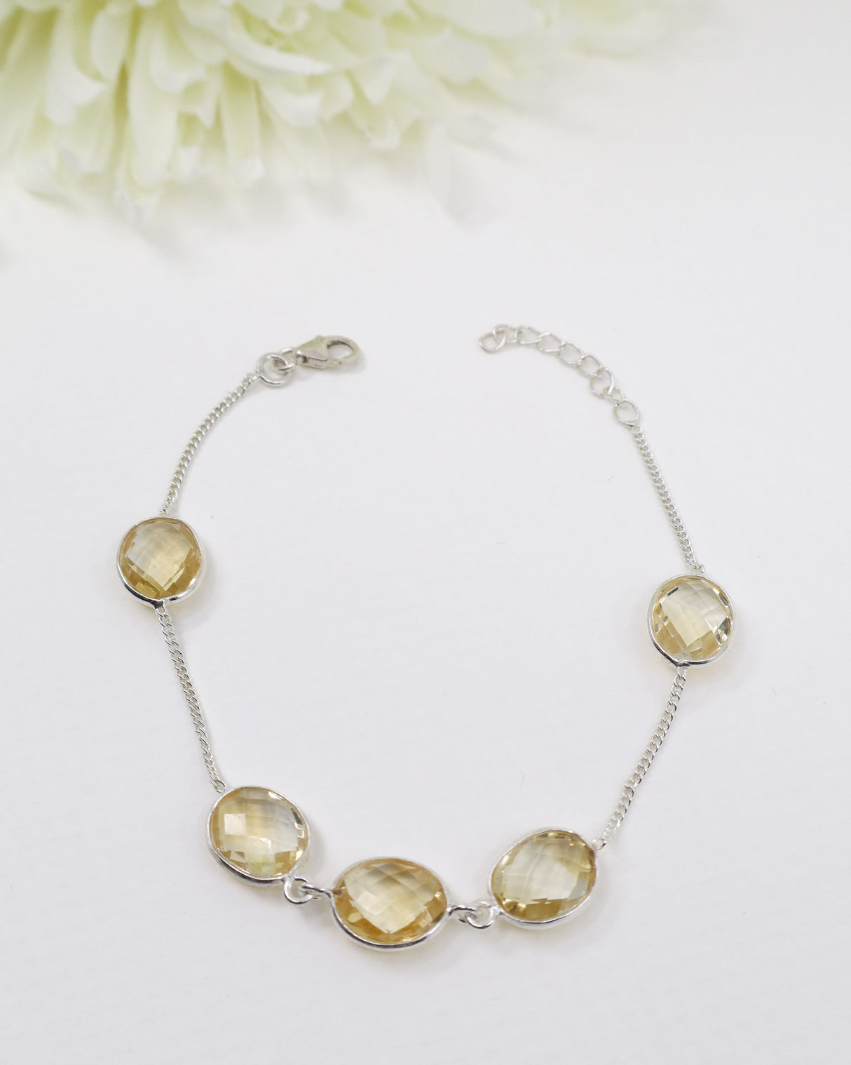 Faceted Citrine sterling silver bracelet displayed beside ruler on wooden background showing delicate gemstone spacing and adjustable chain.