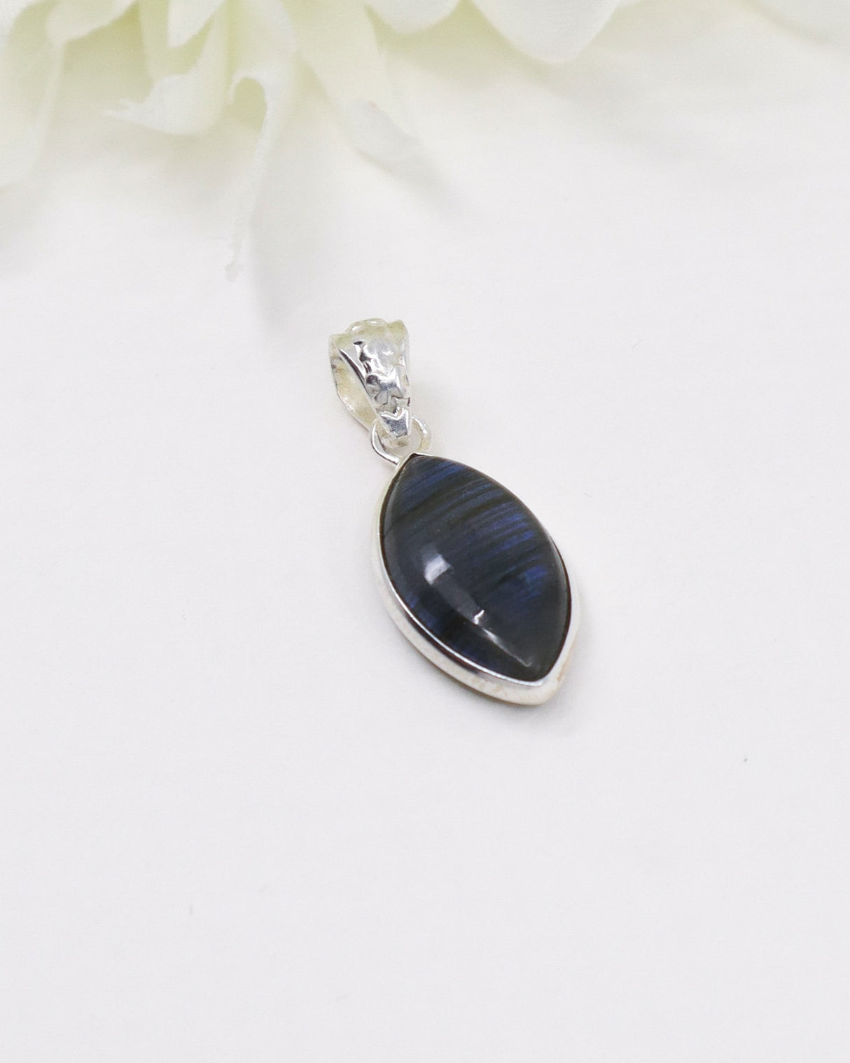 Blue flash Labradorite sterling silver pendant with marquise-shaped gemstone displaying vibrant labradorescence on a white background.
