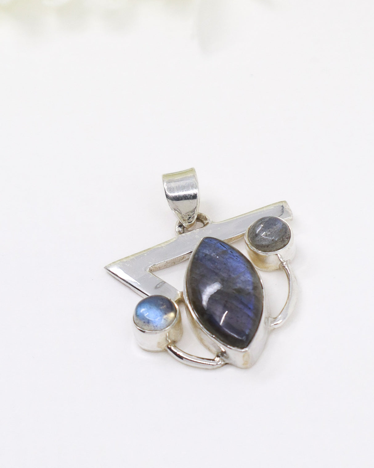 Sterling silver Labradorite pendant with marquise-shaped blue flash gemstone and smaller Labradorite accents on white background.