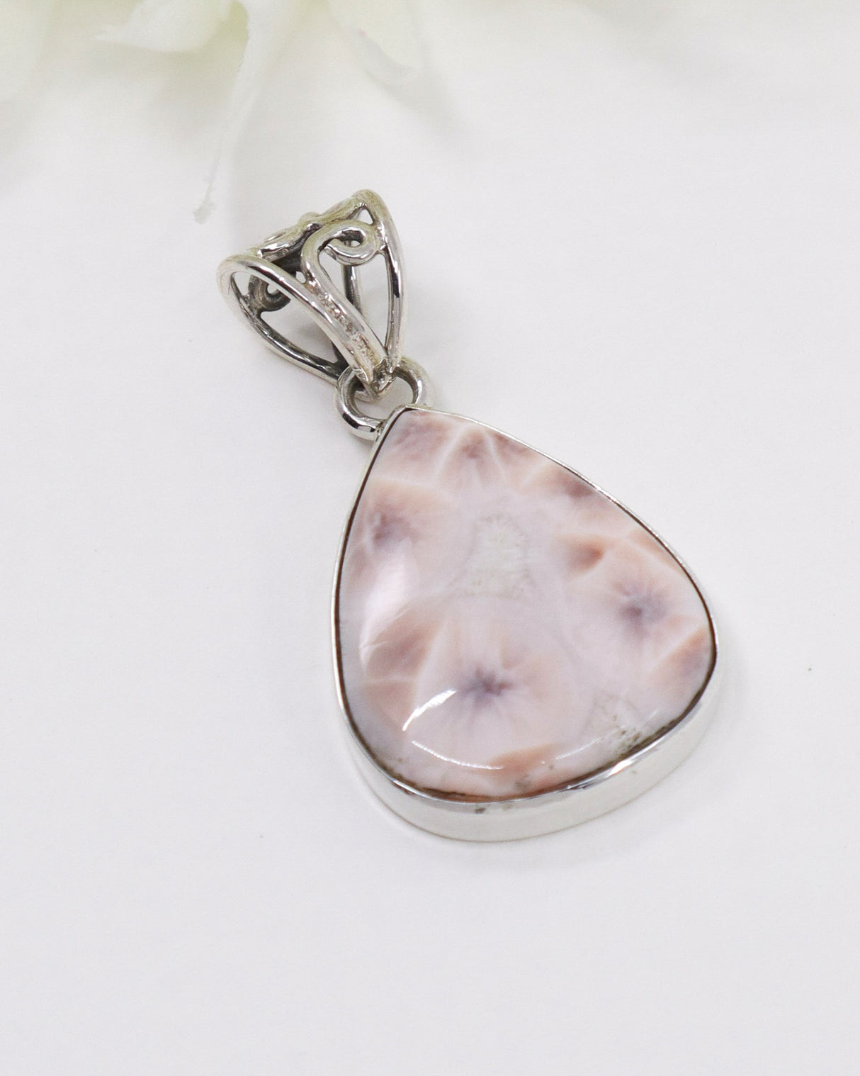 Pink Natrolite (“Pink Larimar”) sterling silver pendant with soft blush orbicular flower patterns photographed on a white background.