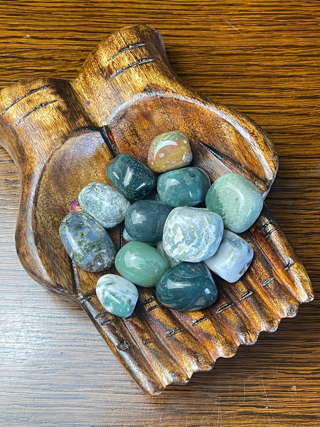 Moss Agate tumbled stone with green moss-like patterns — crystal of growth, prosperity, and new beginnings.