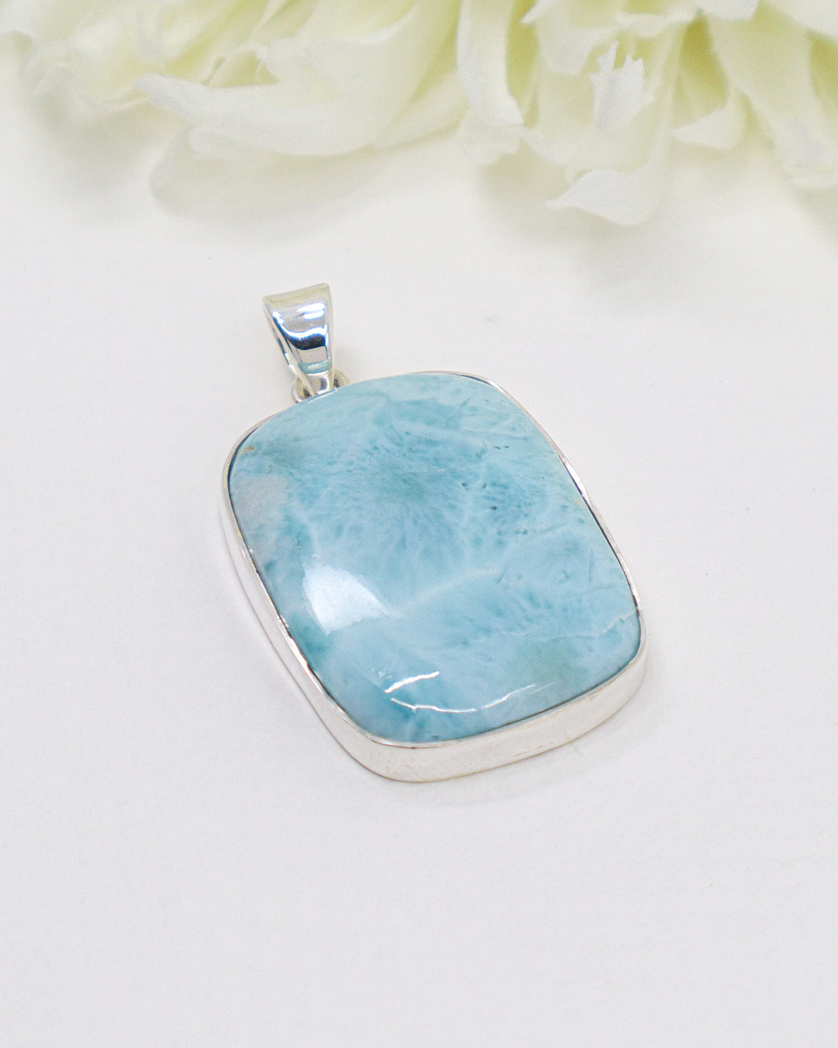 Large rectangular Larimar silver pendant with vivid ocean-blue natural patterns in polished sterling silver setting.