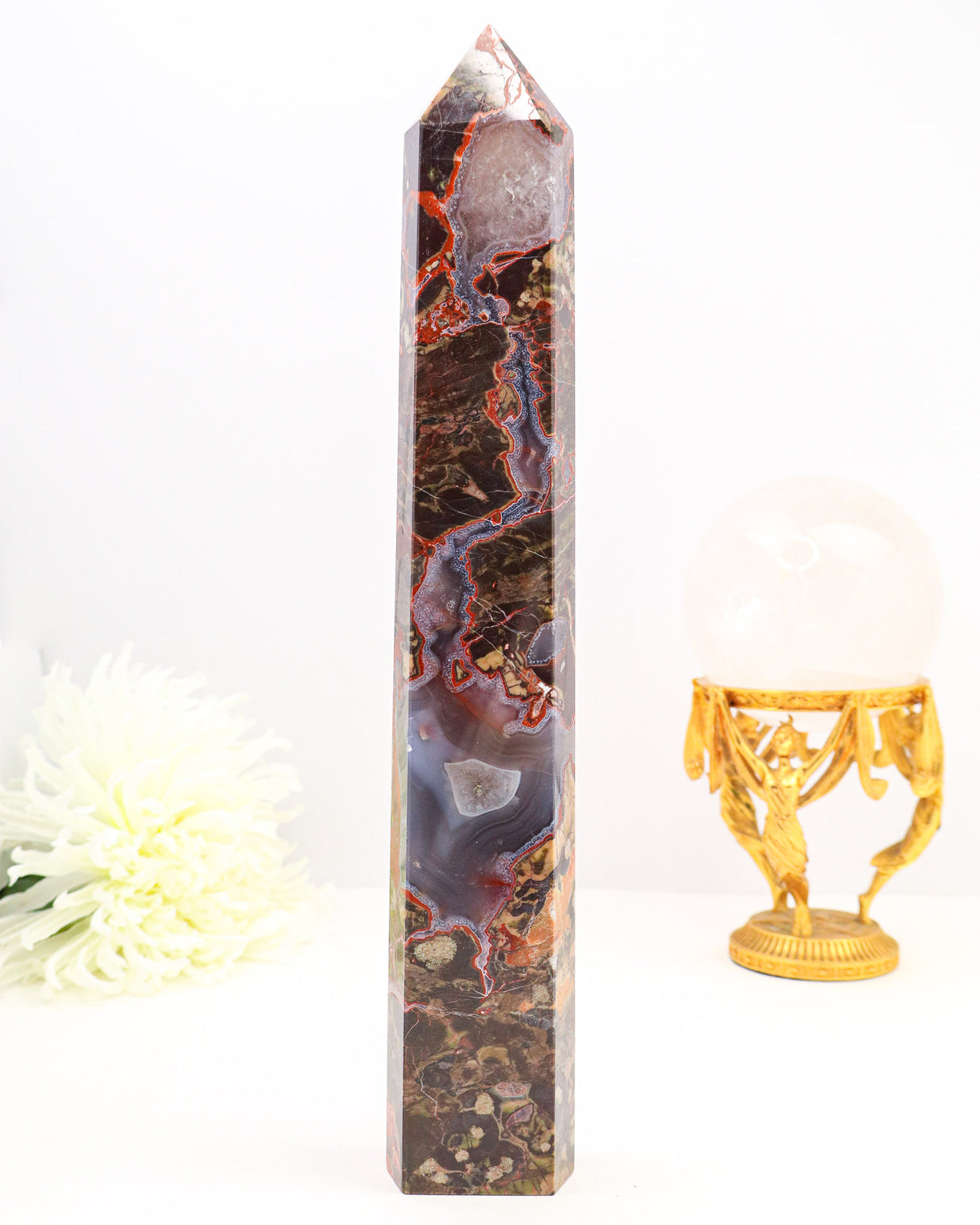 Large polished Money Agate crystal tower featuring rich red veining, earthy natural patterns and sparkling druzy agate sections.