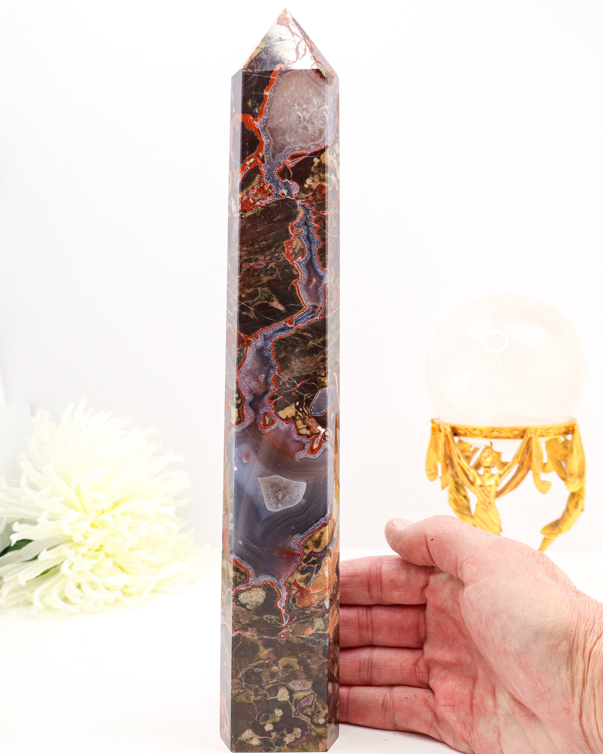 Large polished Money Agate crystal tower featuring rich red veining, earthy natural patterns and sparkling druzy agate sections.