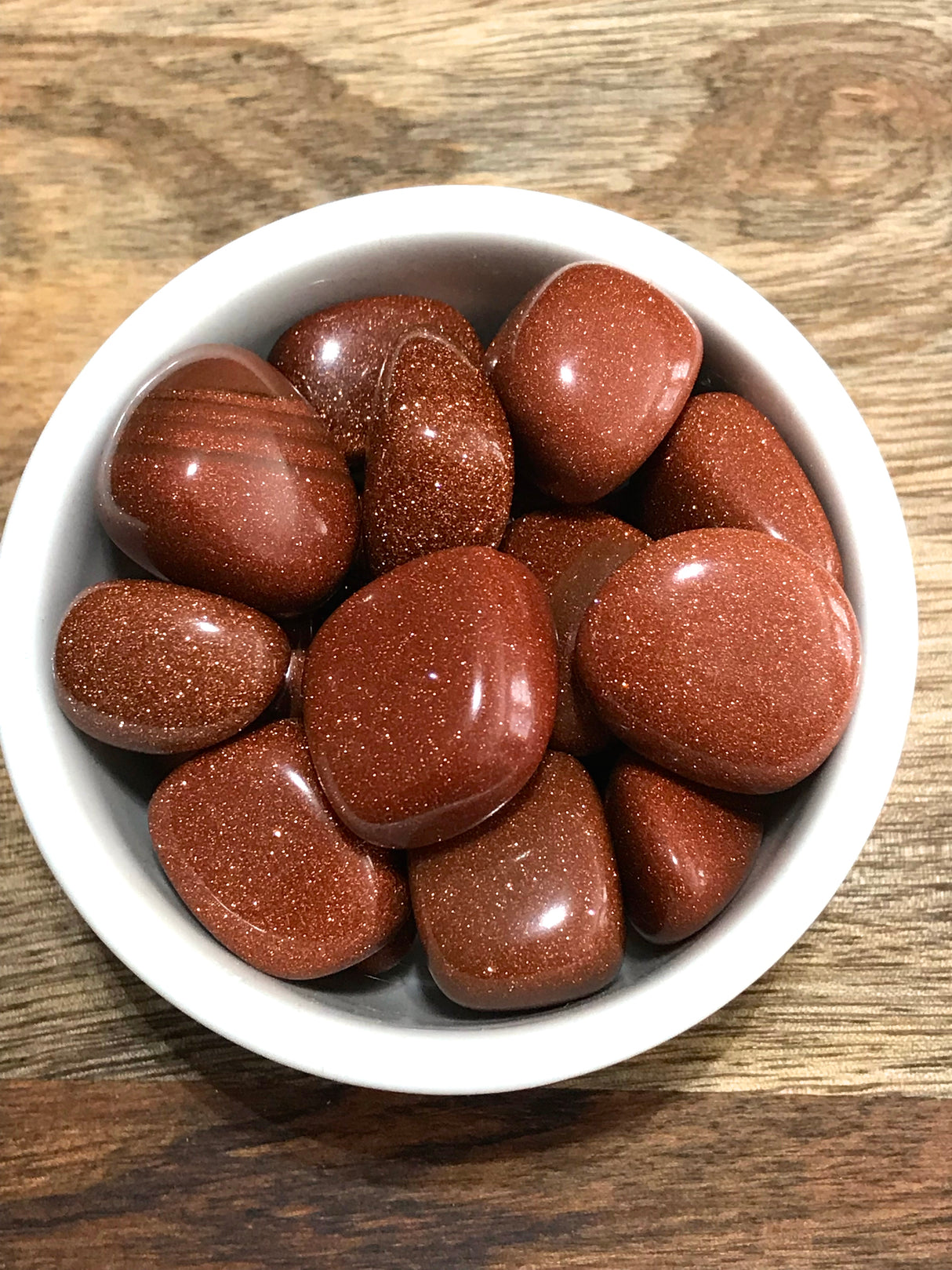 Brown Goldstone tumbled stone with coppery sparkle — crystal of ambition, confidence, and positive energy.