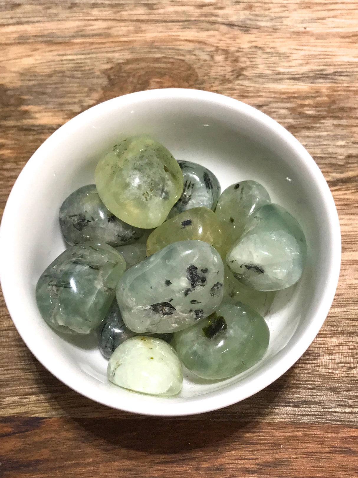Prehnite tumbled stone in soft translucent green — crystal of healing, peace, and divine connection.