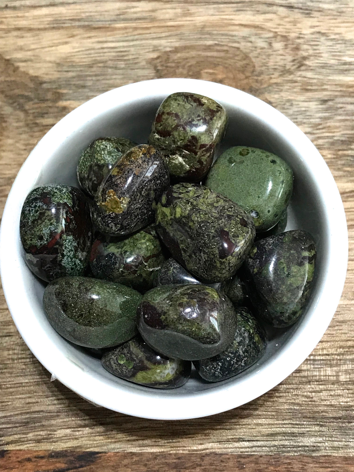 Dragon’s Blood Jasper tumbled stone with deep green and red tones — crystal of courage, vitality, and transformation.