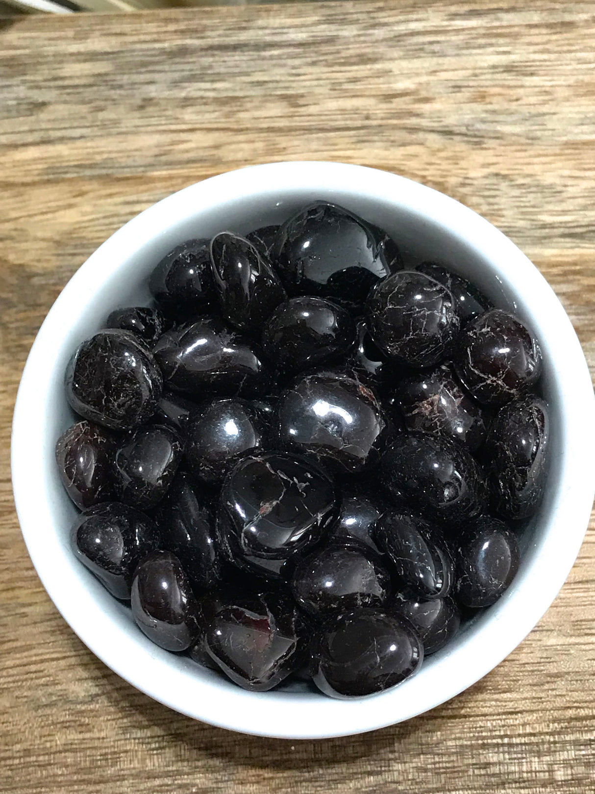 Garnet tumbled stone in deep red tones — crystal of passion, strength, and vitality.