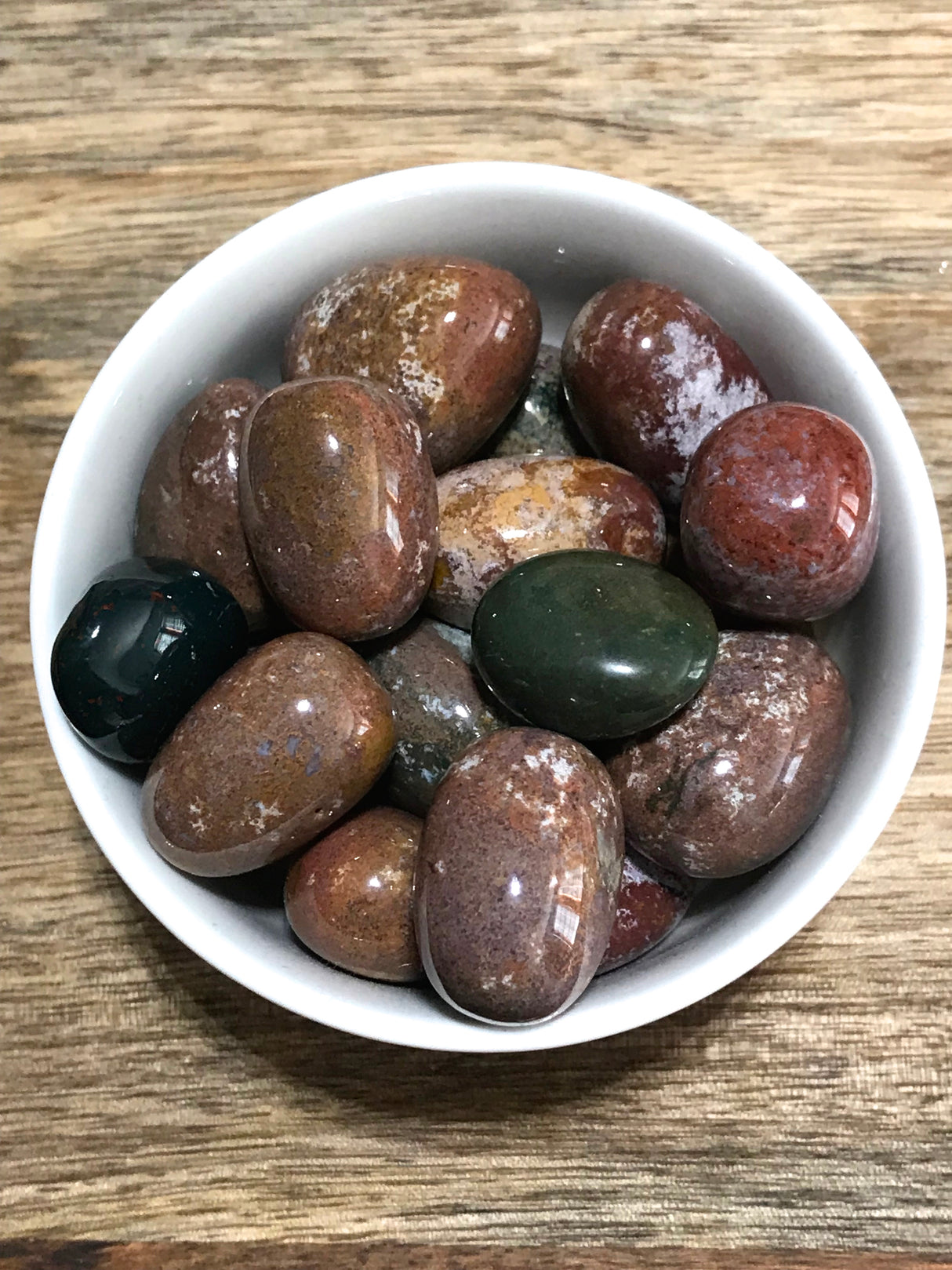 Bloodstone tumbled stone with deep green and red flecks — crystal of courage, vitality, and spiritual protection.
