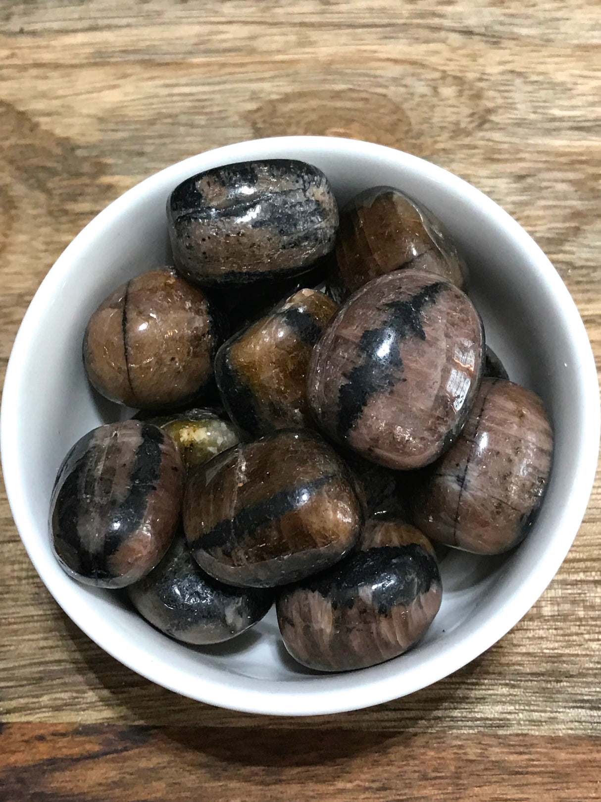 Chiastolite tumbled stone showing its natural cross pattern — crystal of balance, protection, and grounding.