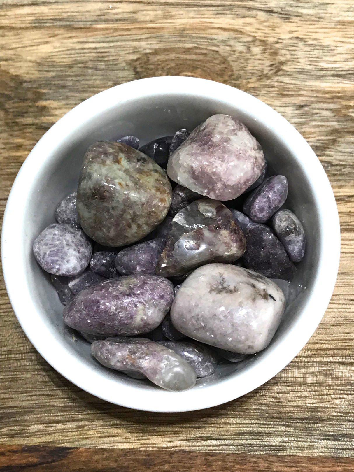 Lepidolite tumbled stone in soft lilac and mauve tones — crystal of calm, balance, and emotional healing.
