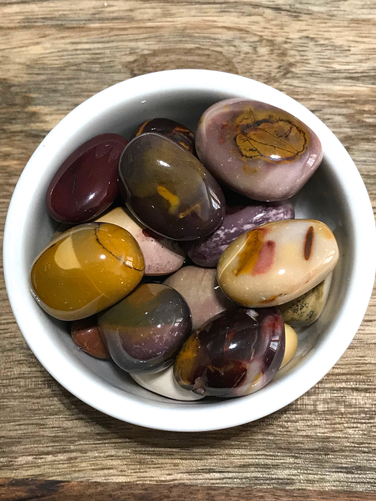 Mookaite Jasper tumbled stone in rich red, yellow, and cream tones — crystal of vitality, adventure, and grounded confidence.