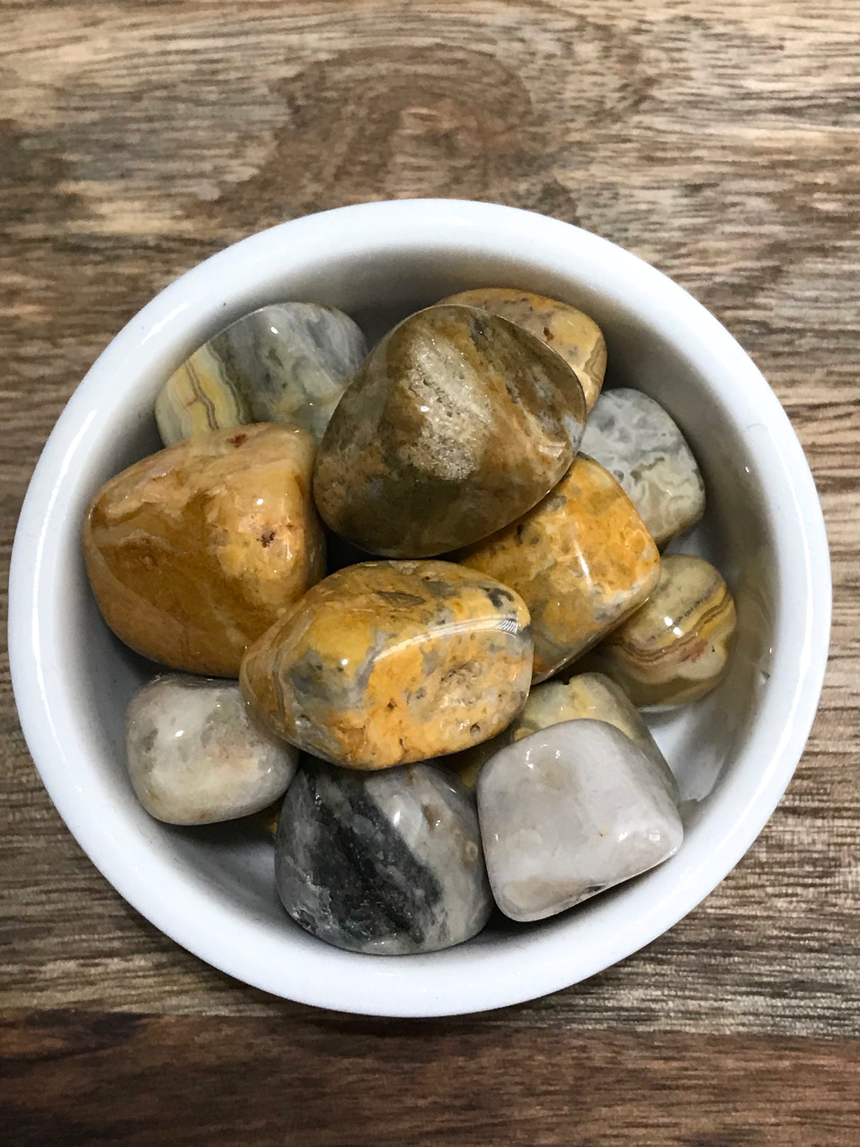 Crazy Lace Agate tumbled stone with swirling cream, gold, and pink patterns — crystal of joy, laughter, and emotional balance.