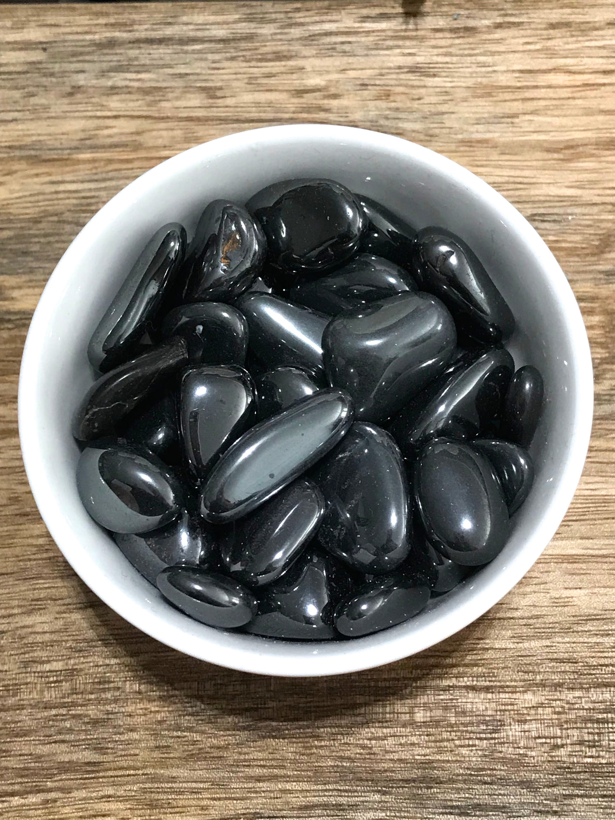Hematite tumbled stone with metallic silver sheen — crystal of grounding, protection, and strength.