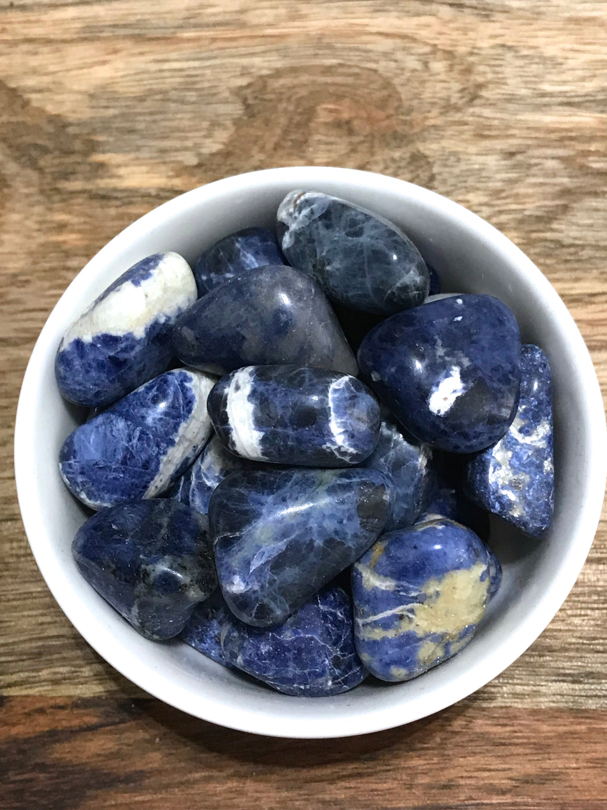 Sodalite tumbled stone in deep blue with white marbling — crystal of intuition, truth, and mental clarity.