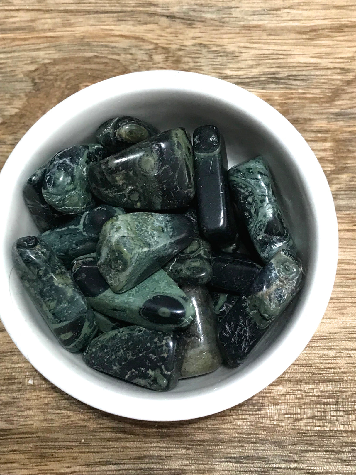 Kambaba Jasper tumbled stone with green and black fossil-like patterns — crystal of peace, grounding, and ancient wisdom.