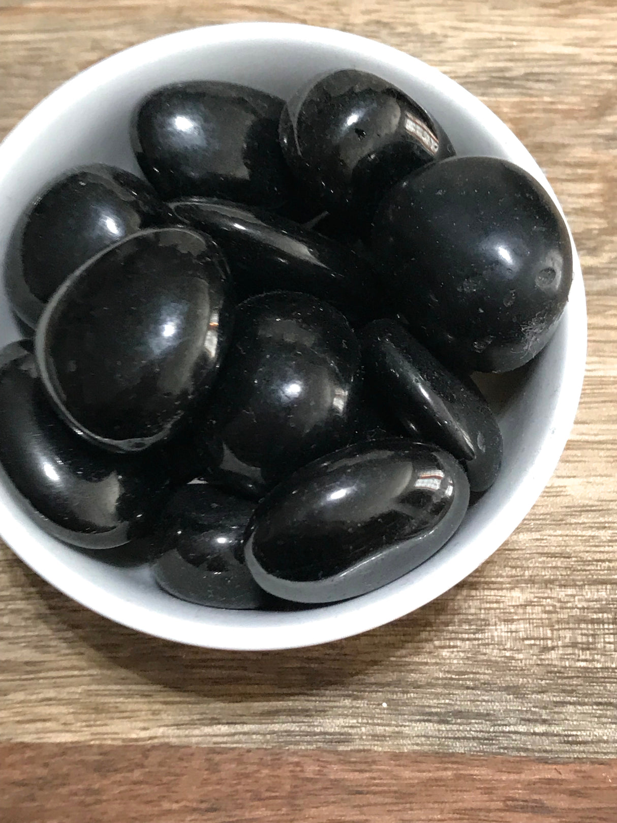 Jet tumbled stone in deep black tones — crystal of protection, purification, and ancestral healing.