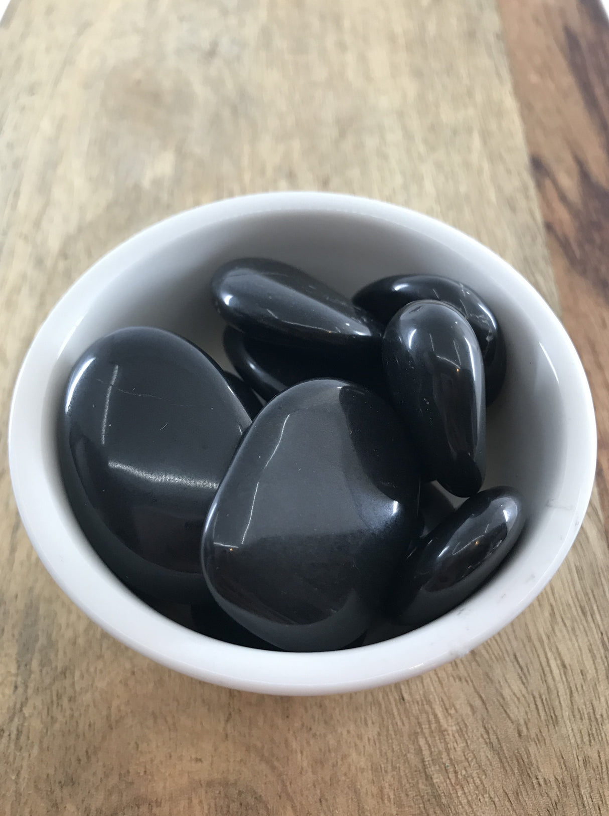Black Agate tumbled stone in glossy black tones — crystal of grounding, strength, and protection.