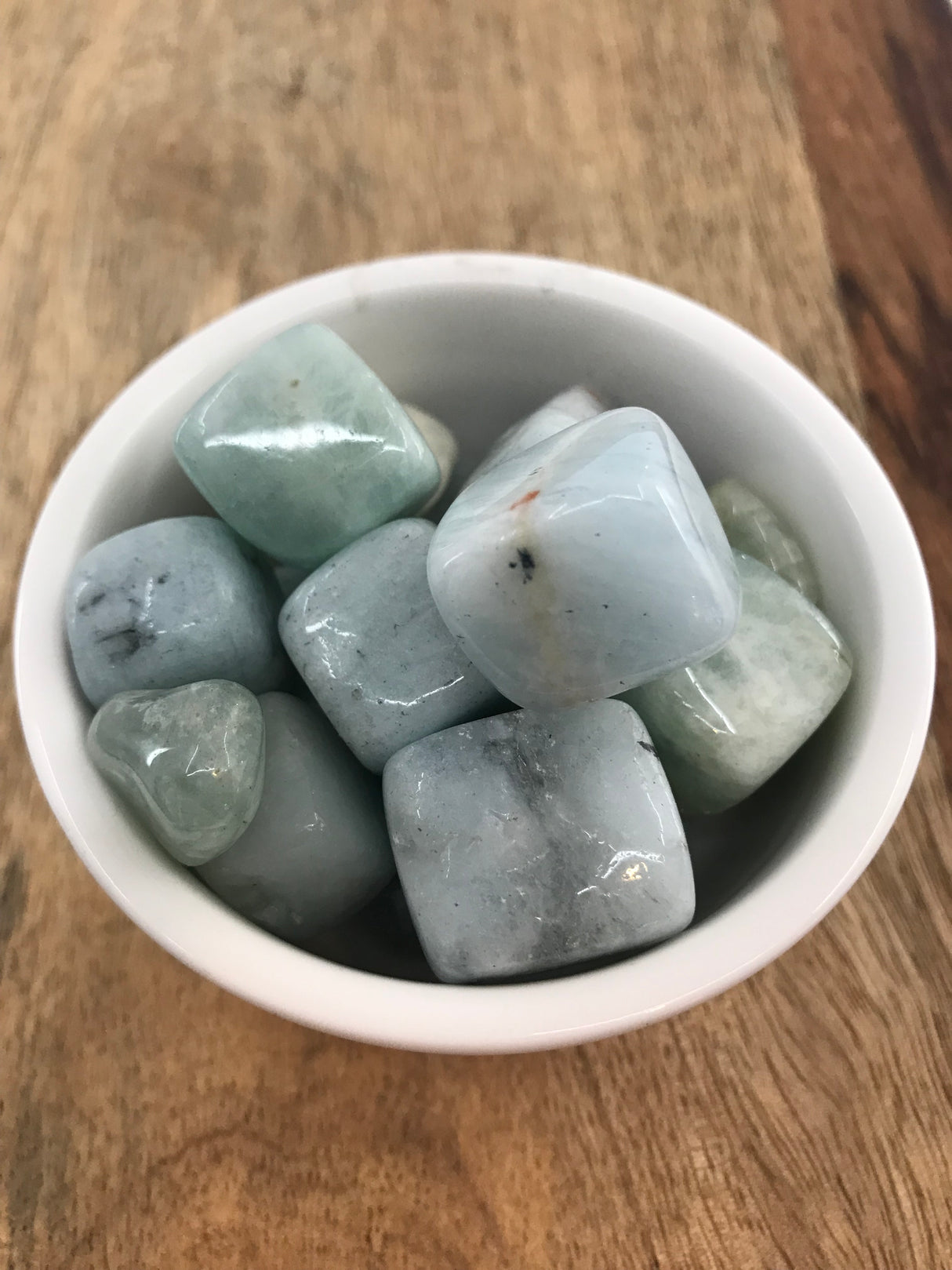 Aquamarine tumbled stone in soft sea-blue tones — crystal of courage, clarity, and emotional flow.