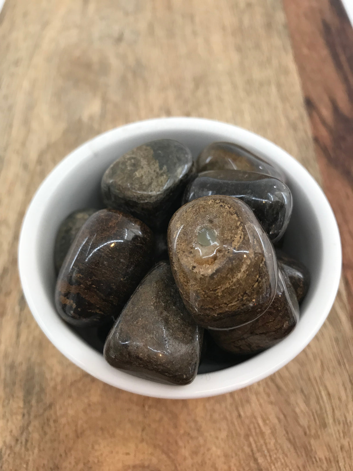 Bronzite tumbled stone with warm bronze shimmer — crystal of grounding, confidence, and protection.