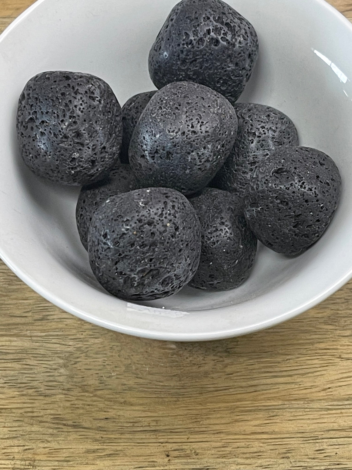 Lava Stone tumbled crystal in deep black tones — stone of strength, courage, and grounding energy.