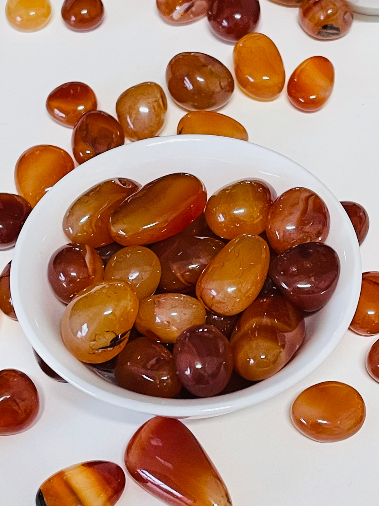 Carnelian tumbled stone in vibrant orange tones — crystal of passion, creativity, and courage.