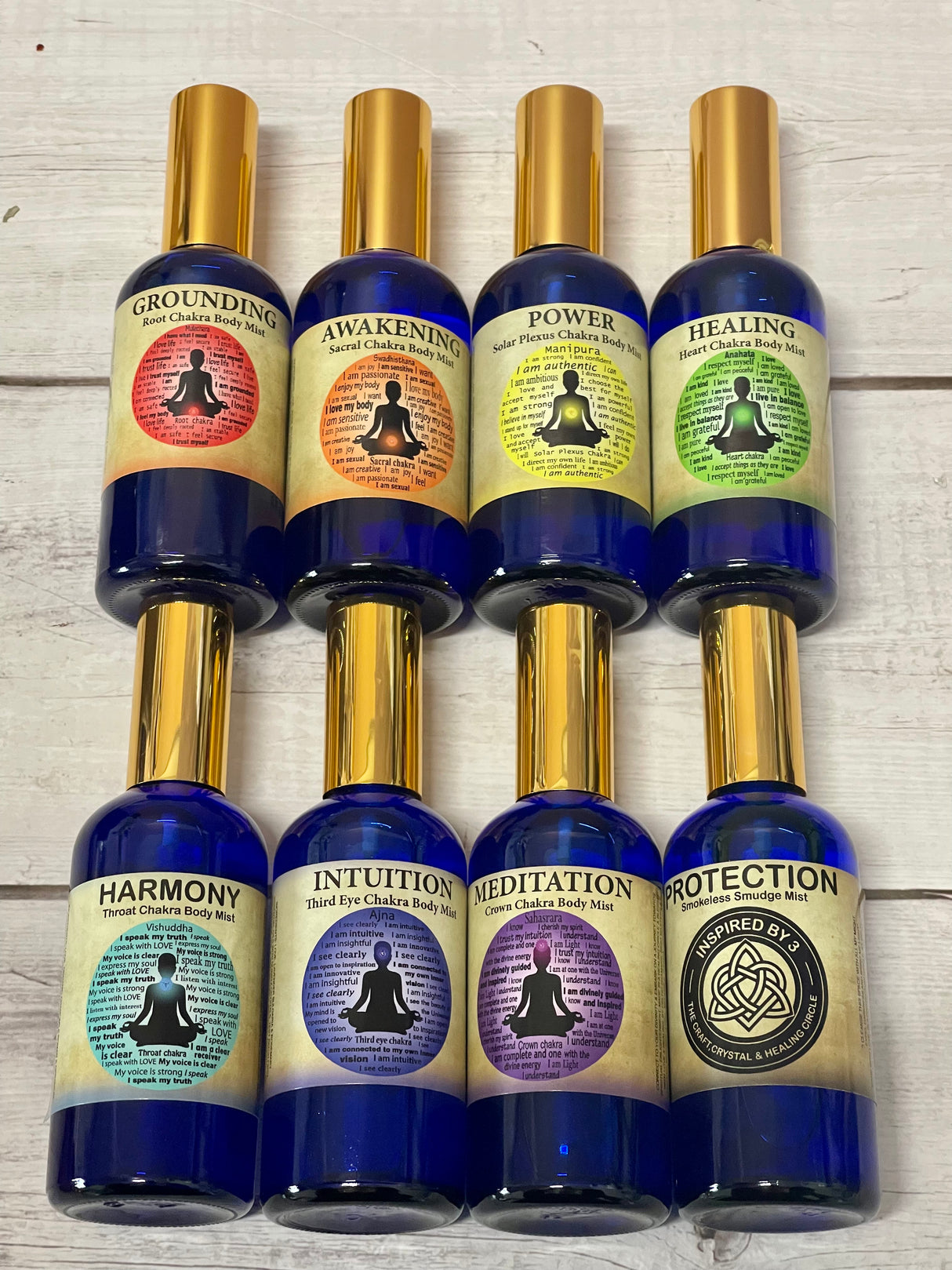 Chakra Body Mist Collection gift box containing eight 100ml bottles with gold atomisers, infused with essential oils and crystal energy by Inspired By 3.