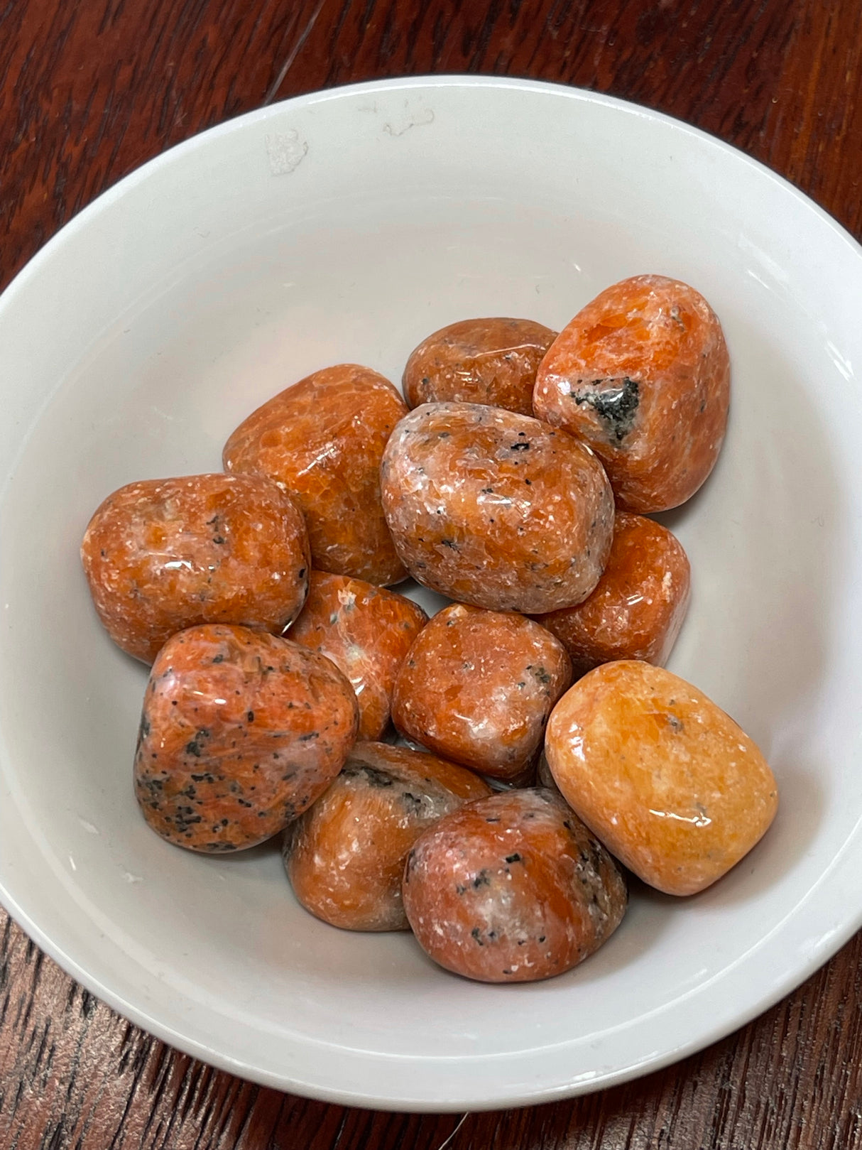 Orchid Calcite tumbled stone in bright orange and red tones — crystal of motivation, confidence, and joyful energy.