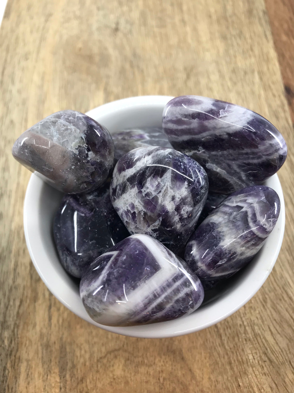 Chevron Amethyst tumbled stone with purple and white bands — crystal of intuition, calm, and spiritual transformation.