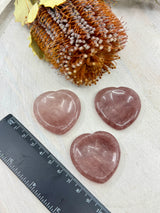 Strawberry Quartz heart worry stone next to a ruler 4x4cm with thumb indent – one piece – pink crystal for love, joy and emotional harmony – Inspired By 3 Crystals Australia.