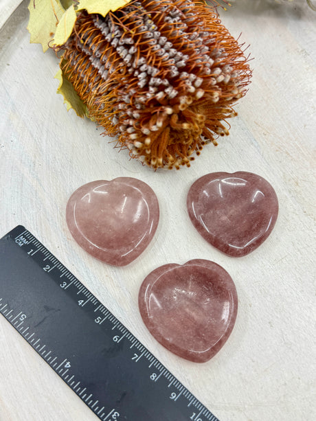 Strawberry Quartz heart worry stone next to a ruler 4x4cm with thumb indent – one piece – pink crystal for love, joy and emotional harmony – Inspired By 3 Crystals Australia.