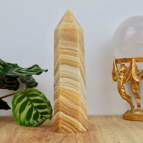 18cm Orange Calcite tower weighing 629g with honey and cream banding polished into a point.