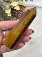 6-Sided Tiger Eye Point 10 cm × 3 cm – golden-brown crystal point symbolising courage, grounding and strength, Inspired By 3 Australia.