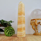 22cm Orange Calcite tower weighing 722g with honey and cream banding polished into a point.
