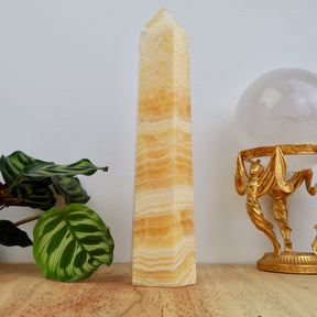 22cm Orange Calcite tower weighing 722g with honey and cream banding polished into a point.