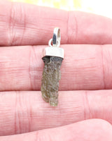 Natural Czech Moldavite pendant in sterling silver featuring a raw elongated green Moldavite crystal with authentic texture and transformational energy.