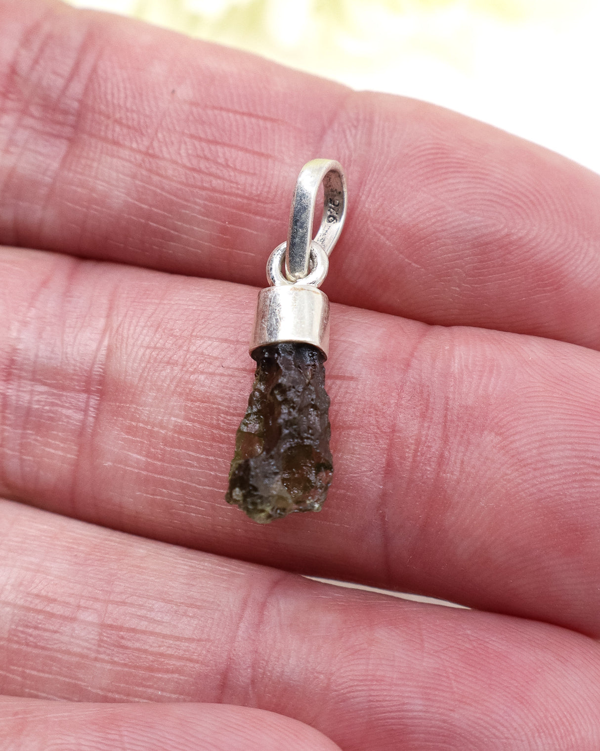 Raw Czech Moldavite pendant in sterling silver featuring a genuine natural green Moldavite crystal with authentic texture and transformational energy.