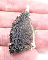 Genuine Czech Moldavite pendant in .925 sterling silver featuring a large natural Moldavite specimen with detailed etched texture, translucent green colouring and cosmic transformational energy from the Czech Republic.