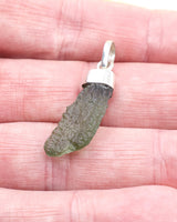 Natural Czech Moldavite pendant in sterling silver featuring an elongated raw green tektite with beautiful texture and powerful transformational energy.