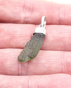 Natural Czech Moldavite pendant in sterling silver featuring an elongated raw green tektite with beautiful texture and powerful transformational energy.