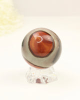 Polished Polychrome Jasper crystal sphere with natural earthy cream, caramel and terracotta patterns displayed on a clear stand against a soft cream background.