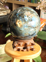 Extra large 5.45kg natural Labradorite crystal sphere with brilliant blue and golden flash on carved wooden stand – Inspired By 3 Australia