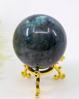 Genuine Labradorite Crystal Sphere 284g featuring vibrant blue labradorescence flashes displayed on a decorative gold stand.